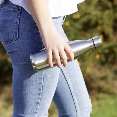 bouteille isotherme inox tenue par femme en balade