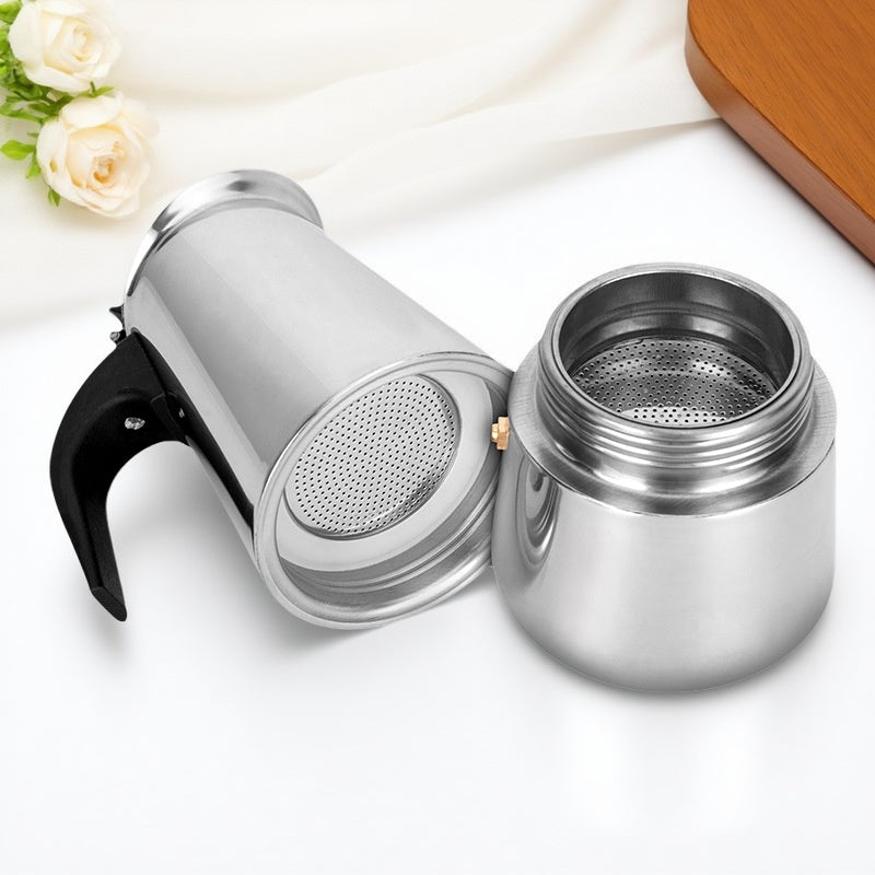 cafetière italienne inox en piece ouverte sur nappe blanche rose blanche planche bois a cote