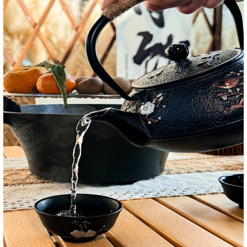 une personne ayant theiere japonaise servant the dans une tasse noire