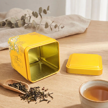boite pour le the jaune ouverte sur table tasse the the en vrac  serviette tige de fleur en decor