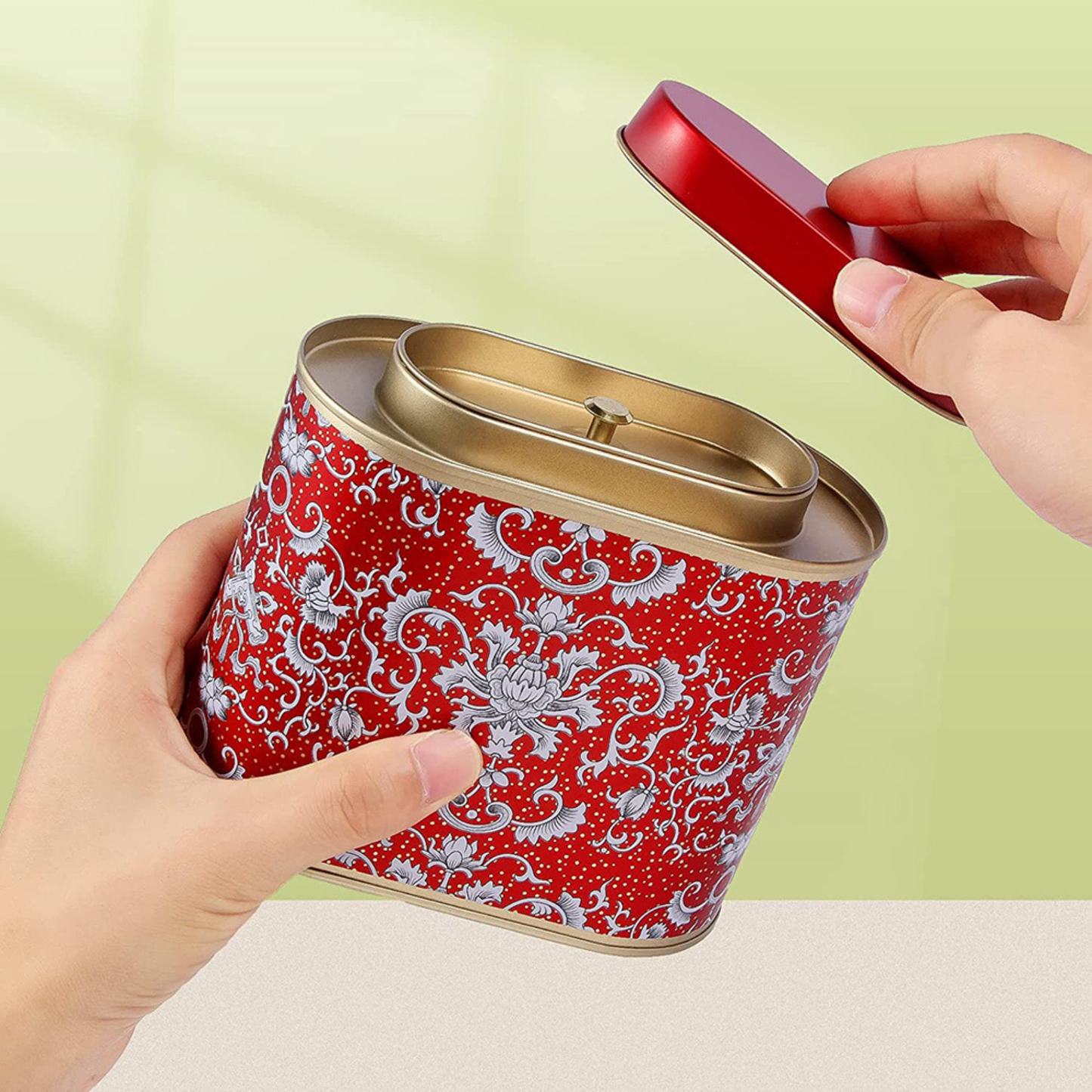 boites à thé rouge motif ouvert tenue par une personne