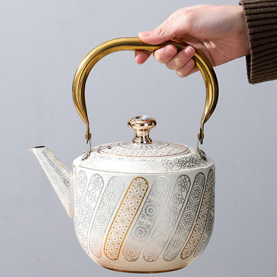 bouilloire et theiere tenue par une femme