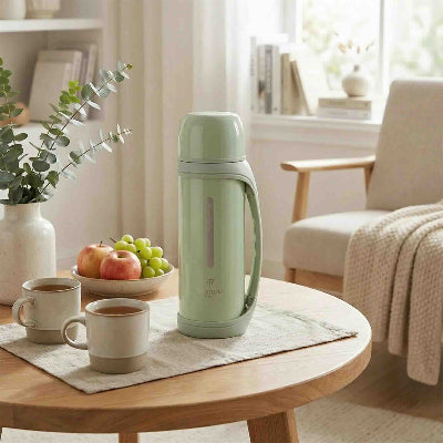 bouteille d eau isotherme verte sur table tasse the bol fruit a cote