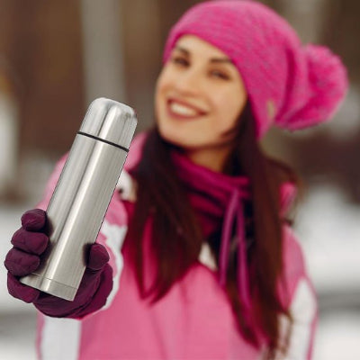 bouteille inox isotherme grise tenue par femme en rose