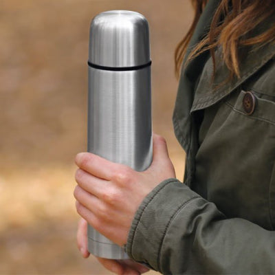 bouteille inox isotherme grise tenue par femme en verte