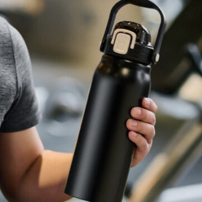 bouteille isotherme 2l noire tenue par un homme