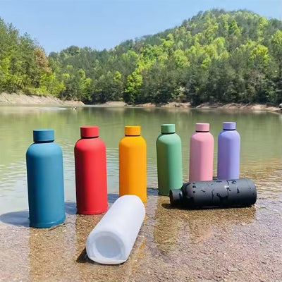 bouteille isotherme bleu rouge jaune verte rose mauve noire et blanche au bord lac