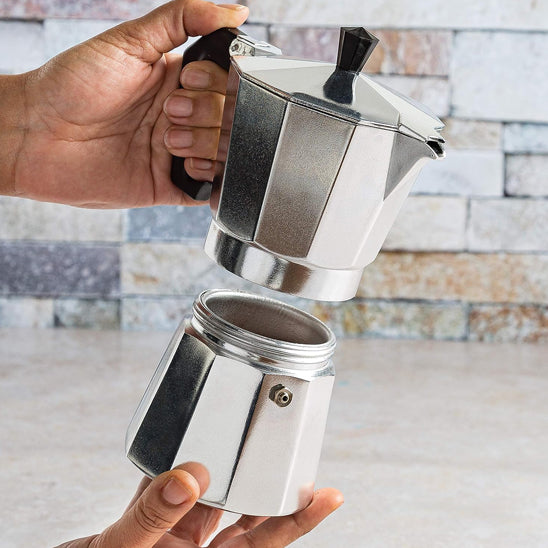 cafetiere italienne en piece tenue par une personne