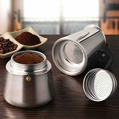  cafetiere italienne inox ouverte sur table bois avec mouture cafe pres a etre utilise
