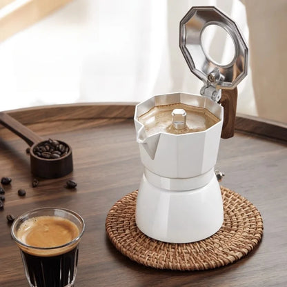 cafetiere italienne moka blanche ouverte remplit de cafe sur table bois tasse cafe et cuillere grain de cafe doseur a cote