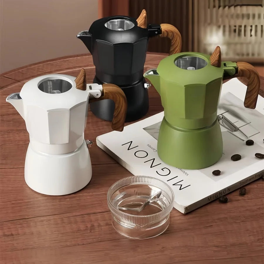 cafetiere italienne moka verte noire blanche sur table bois livre niveleur cafe a cote