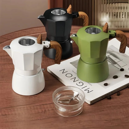 cafetiere italienne moka verte noire blanche sur table bois livre niveleur cafe a cote