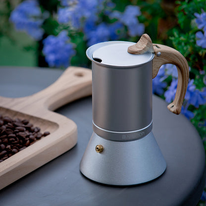 cafetières italiennes sur table planche bois avec grain cafe fleur en decor