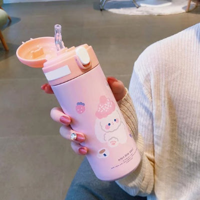 gourde enfant isotherme rose pastel tenue par une personne