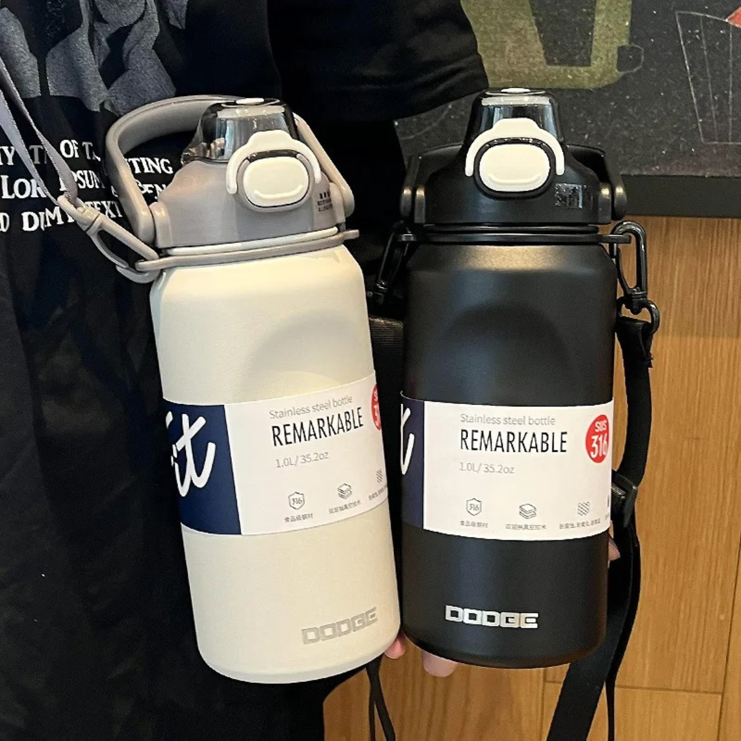 gourde isotherme 1 litre noire et blanc montre par une personne