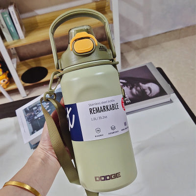 gourde isotherme un litre verte tenue par femme