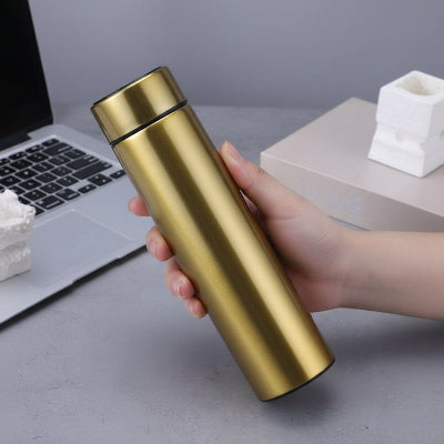 gourde isotherme doree tenue par femme au bureau