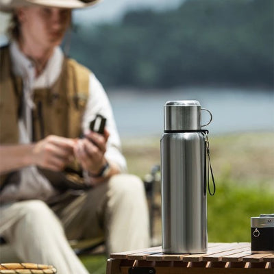 gourde isotherme inox grise utilise en pique nique