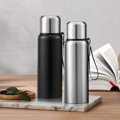 gourde isotherme inox intelligente noire et grise sur plateau en ceramique