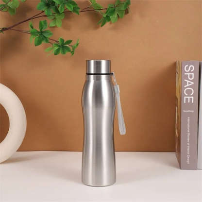 gourde isotherme inox sur table livre fleur à coté fond orange