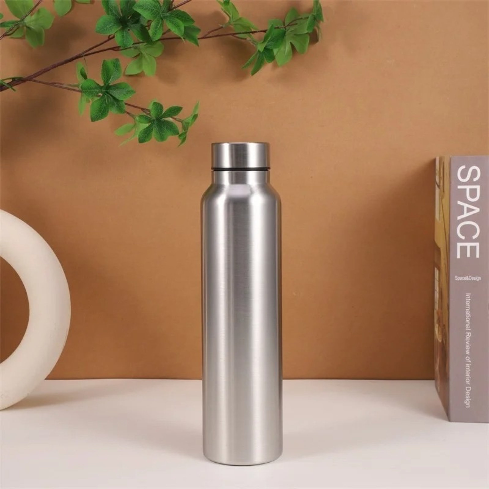 gourde isotherme inox sur table livre plante à coté