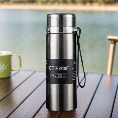 gourde isotherme sport grise sur table marron