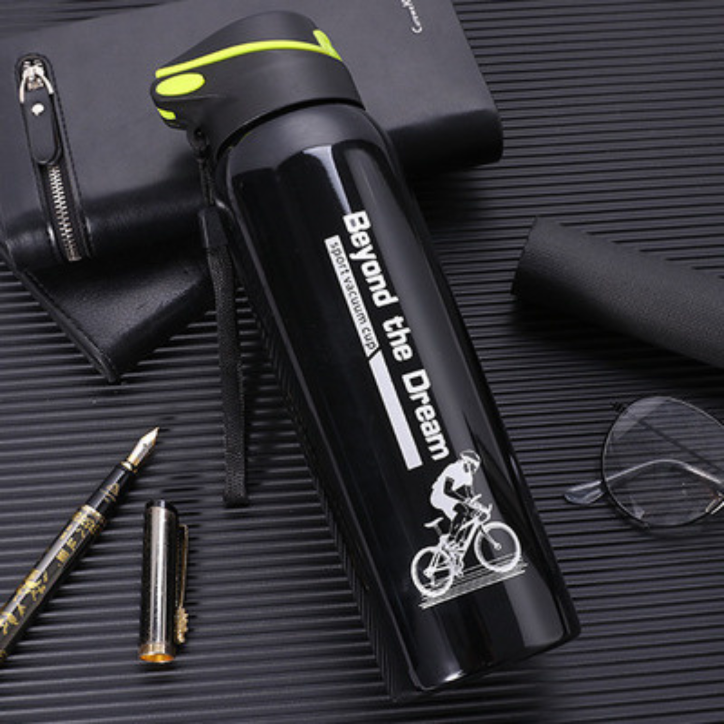 gourde isotherme velo noire sur table calpin lunette stylo a cote