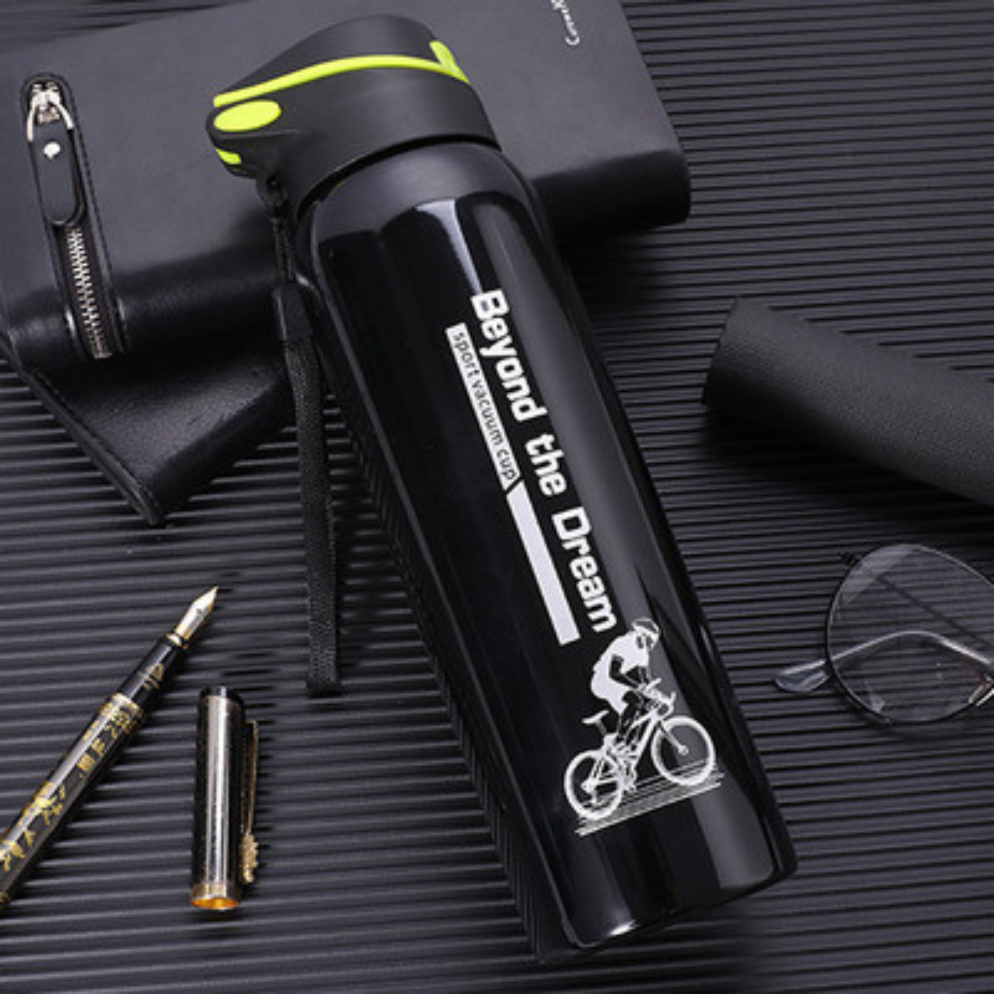 gourde isotherme velo noire sur table calpin lunette stylo a cote