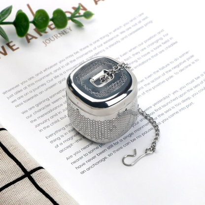 infuseur a thé sur livre ouverte tige verte à coté