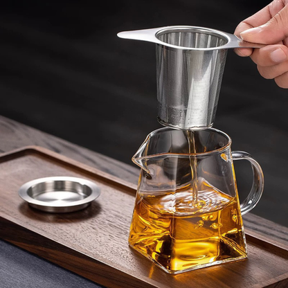 infuseur pour théière utilise par une personne tasse the sur planche bois