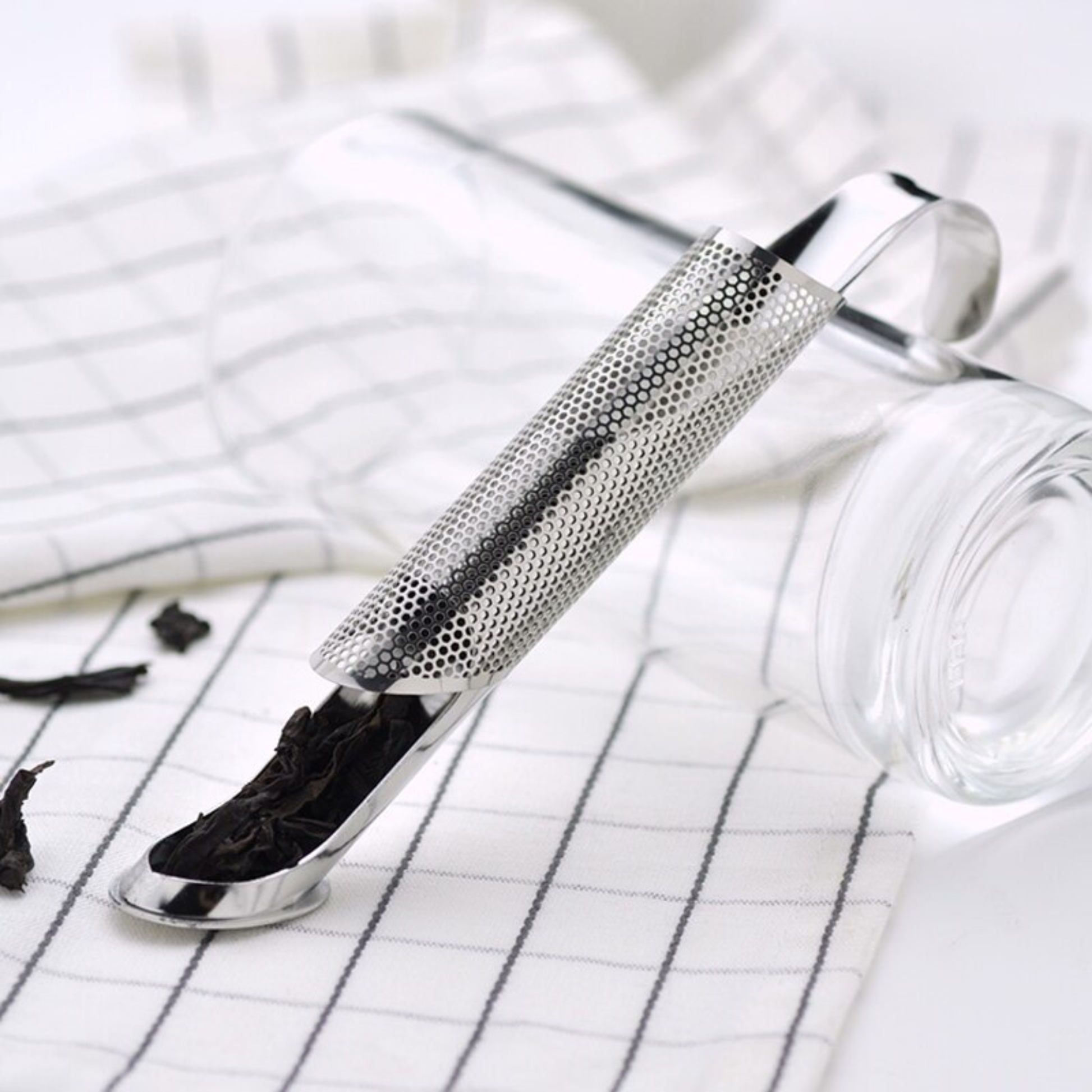 infuseur thé sur serviette remplit de thé verre à coté