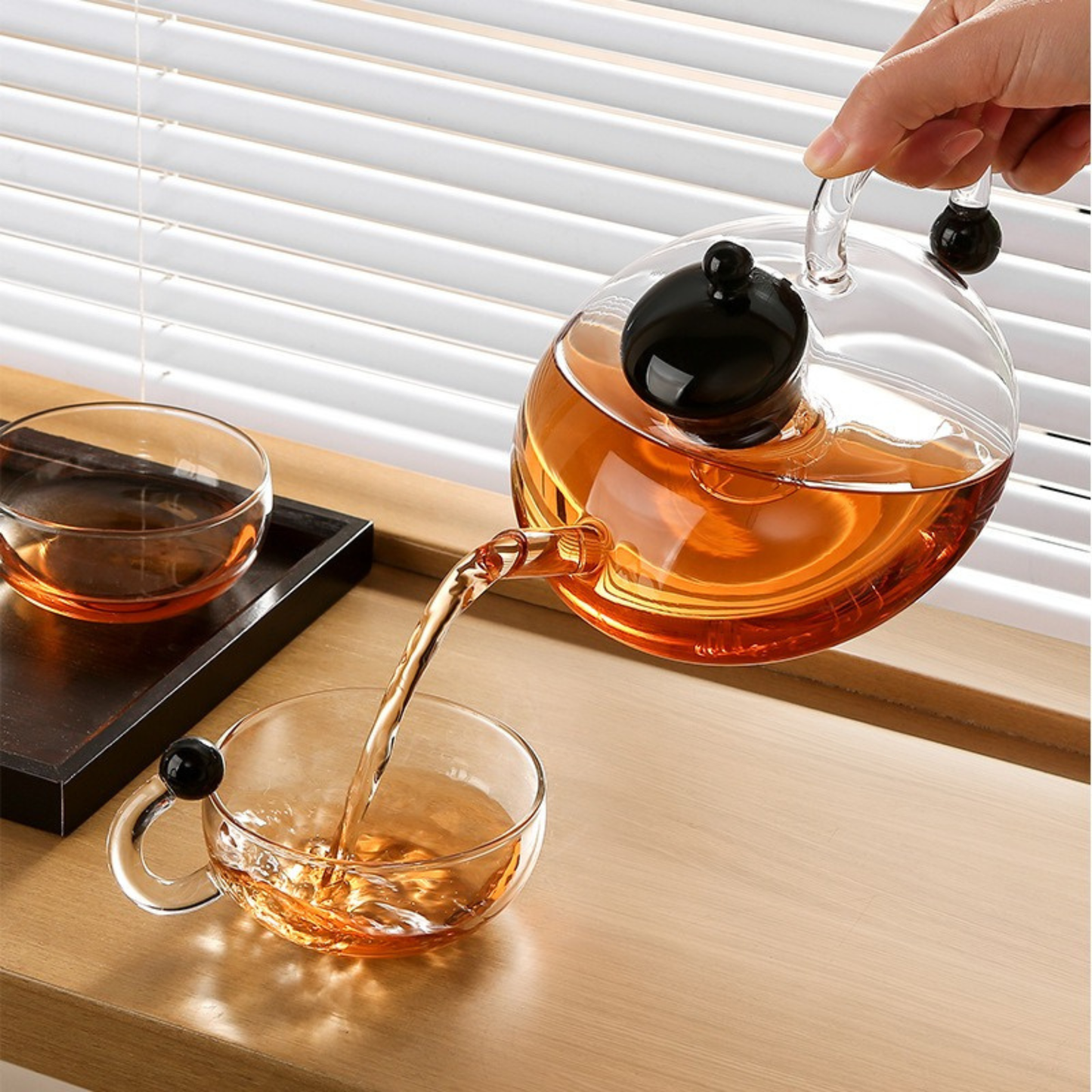 infuseur theiere couvert noire en service par une femme