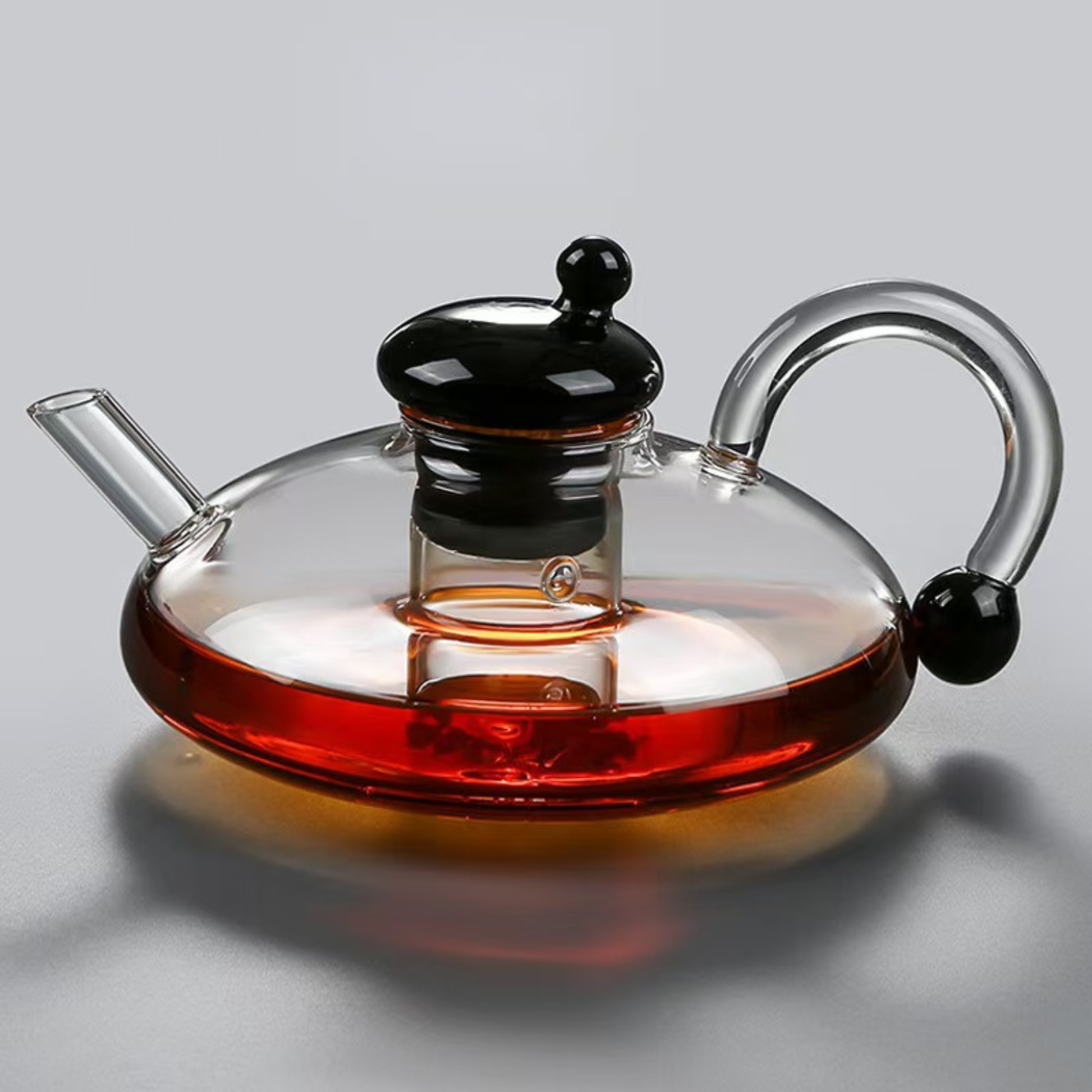 infuseur theiere couvert noire sur table grise