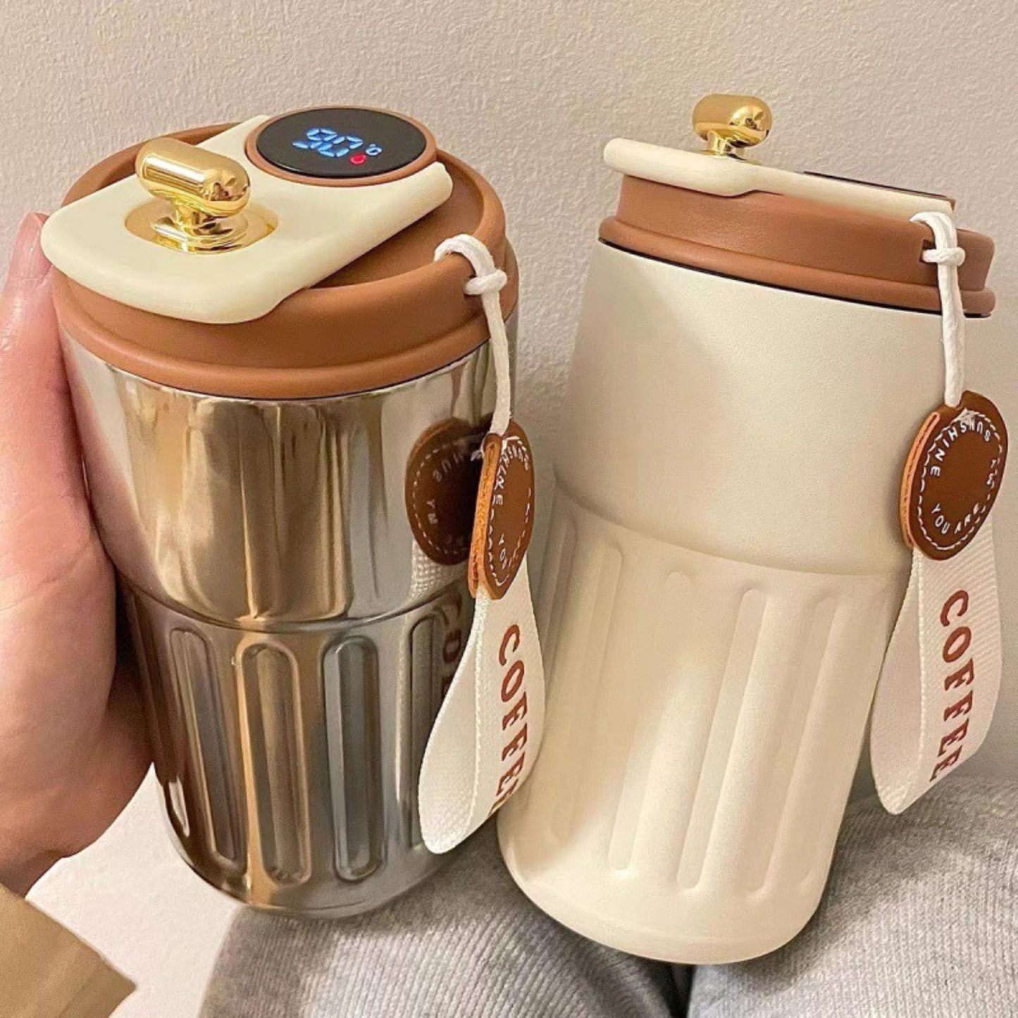 mug cafe isotherme blanc et argentée marron tenue par une femme