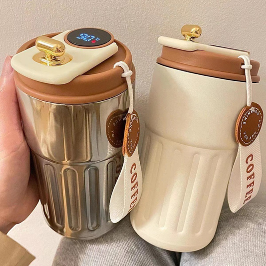 mug cafe isotherme blanc et argentée marron tenue par une femme