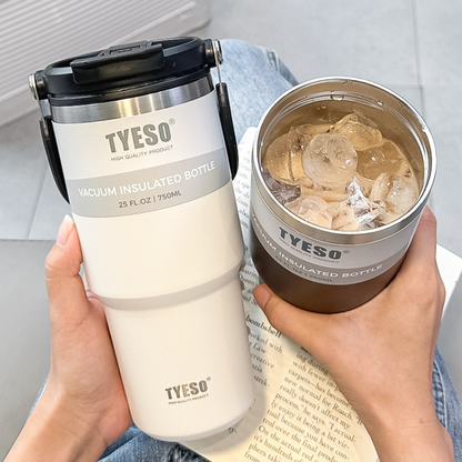 mug de voyage isotherme noire remplit de café au lait glacé et un blanc tenue par une femme lisant son livre