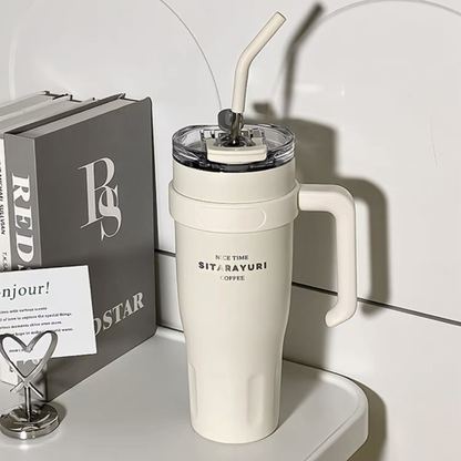 mug isotherme avec paille blanche sur table livre à coté