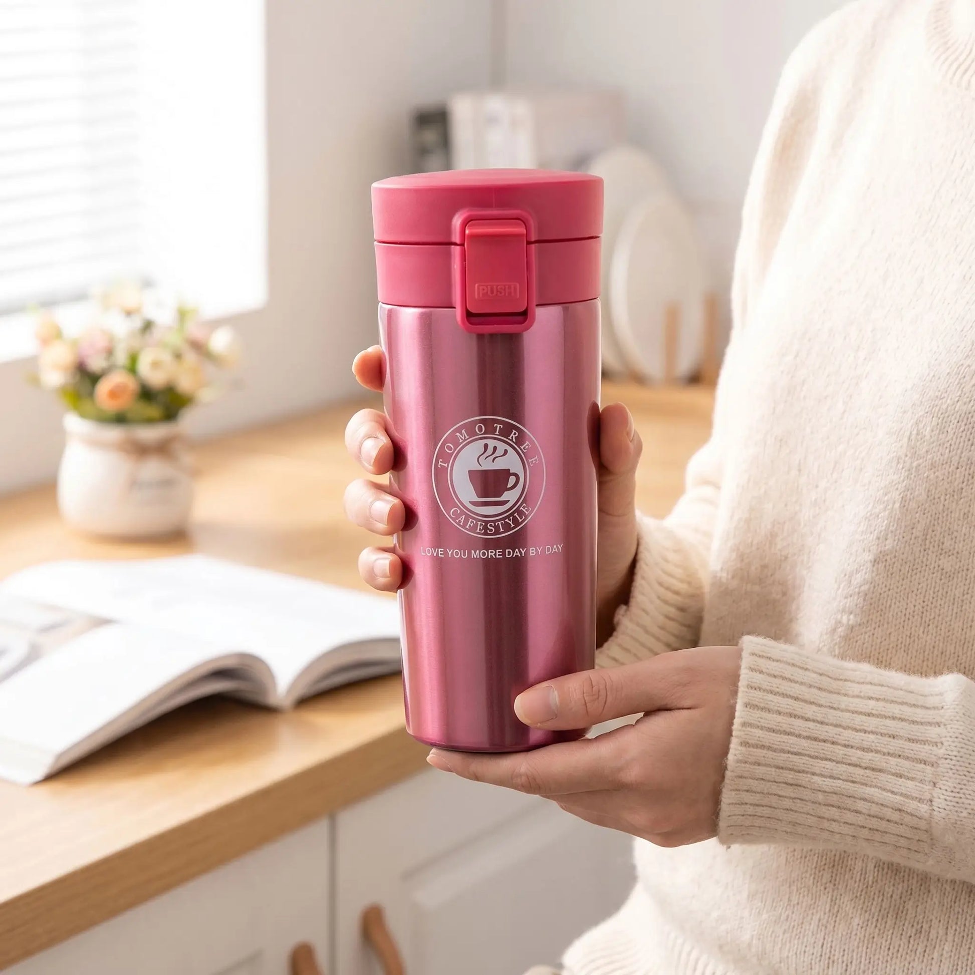 mug isotherme inox rouge tenue par une femme en cuisine
