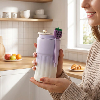 mug isotherme mauve tenue par une femme en cuisine croissant fruit a cote