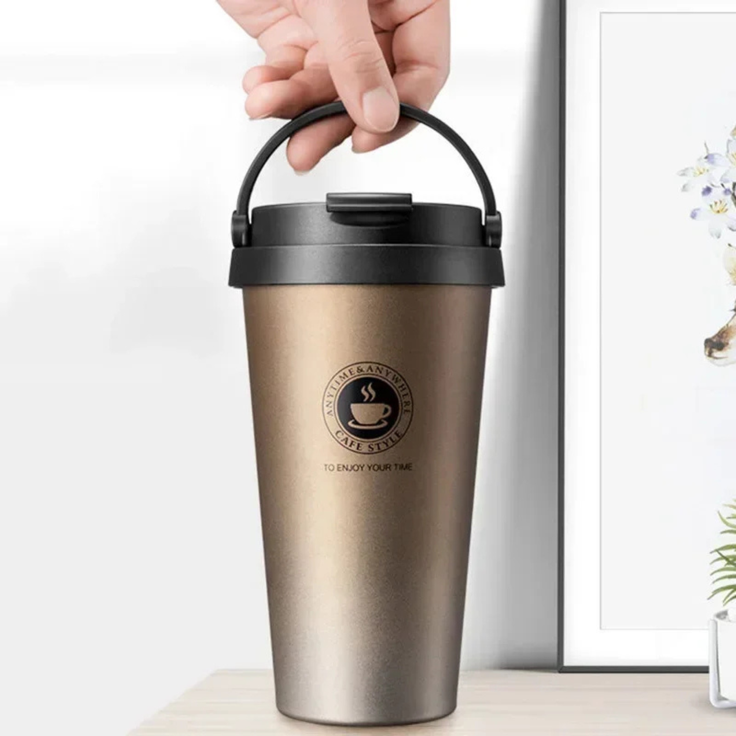 mugs isothermes dorée tenue par une personne