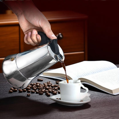 personne servant cafe avec cafetière italienne inox grain cafe tasse livre en decor