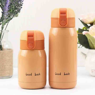 petite bouteille isotherme orange sur table fleur en decor