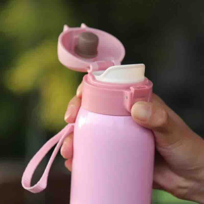petite bouteille isotherme rose tenue par une personne