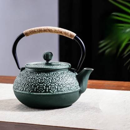 theiere en fonte de couleur verte sur table nappe marron