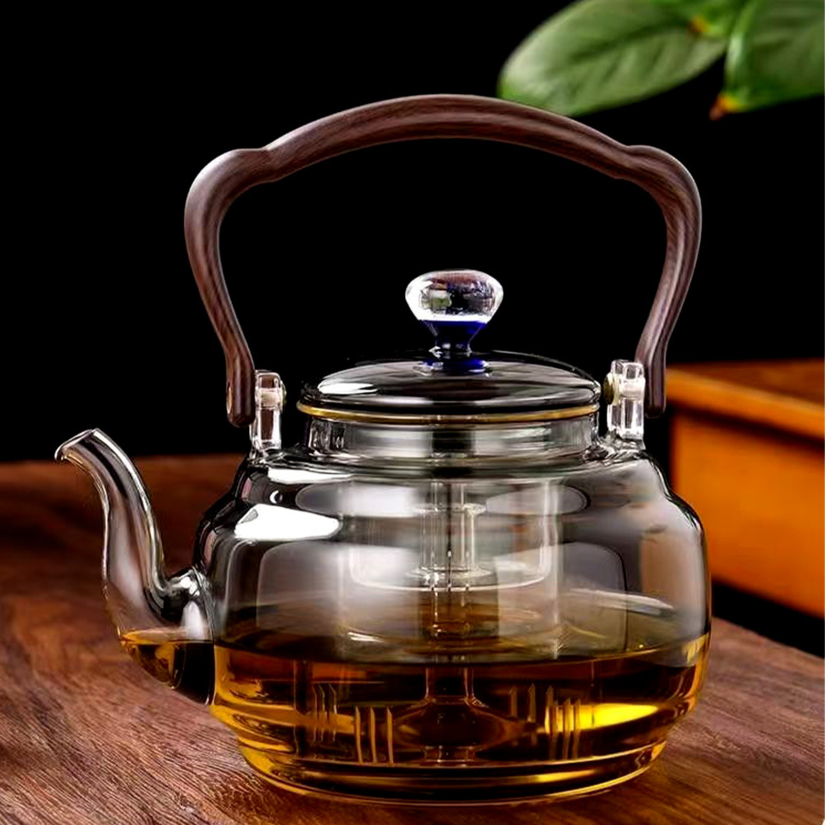 théière en verre avec infuseur remplit thé sur table bois