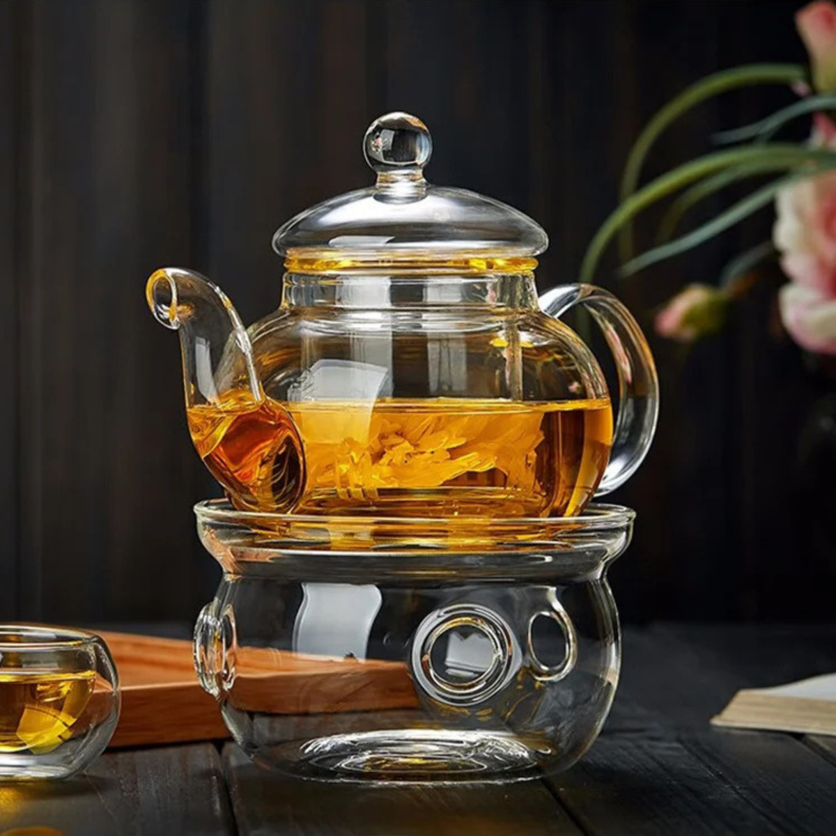 théière en verre transparent remplit thé sur support verre tasse plateau sur le coté